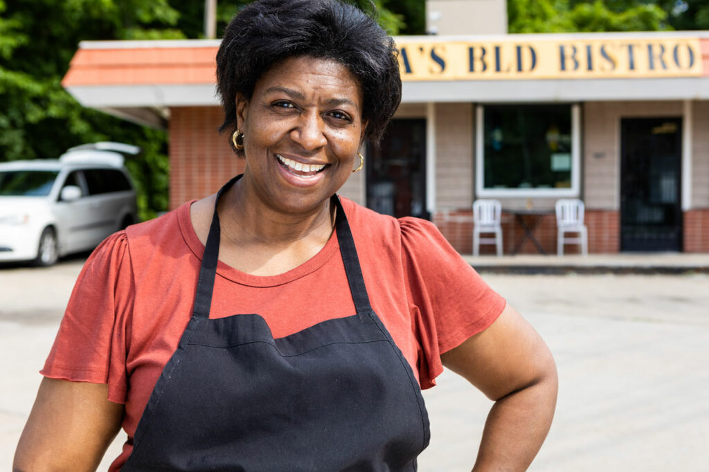 Angelynn Howell stands in front of her restaurant in a black apron