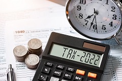 Tax 2022 on calculator determining 2022 tax law impacts. 