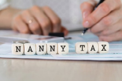 Person calculating nanny tax and nanny tax written on dice.